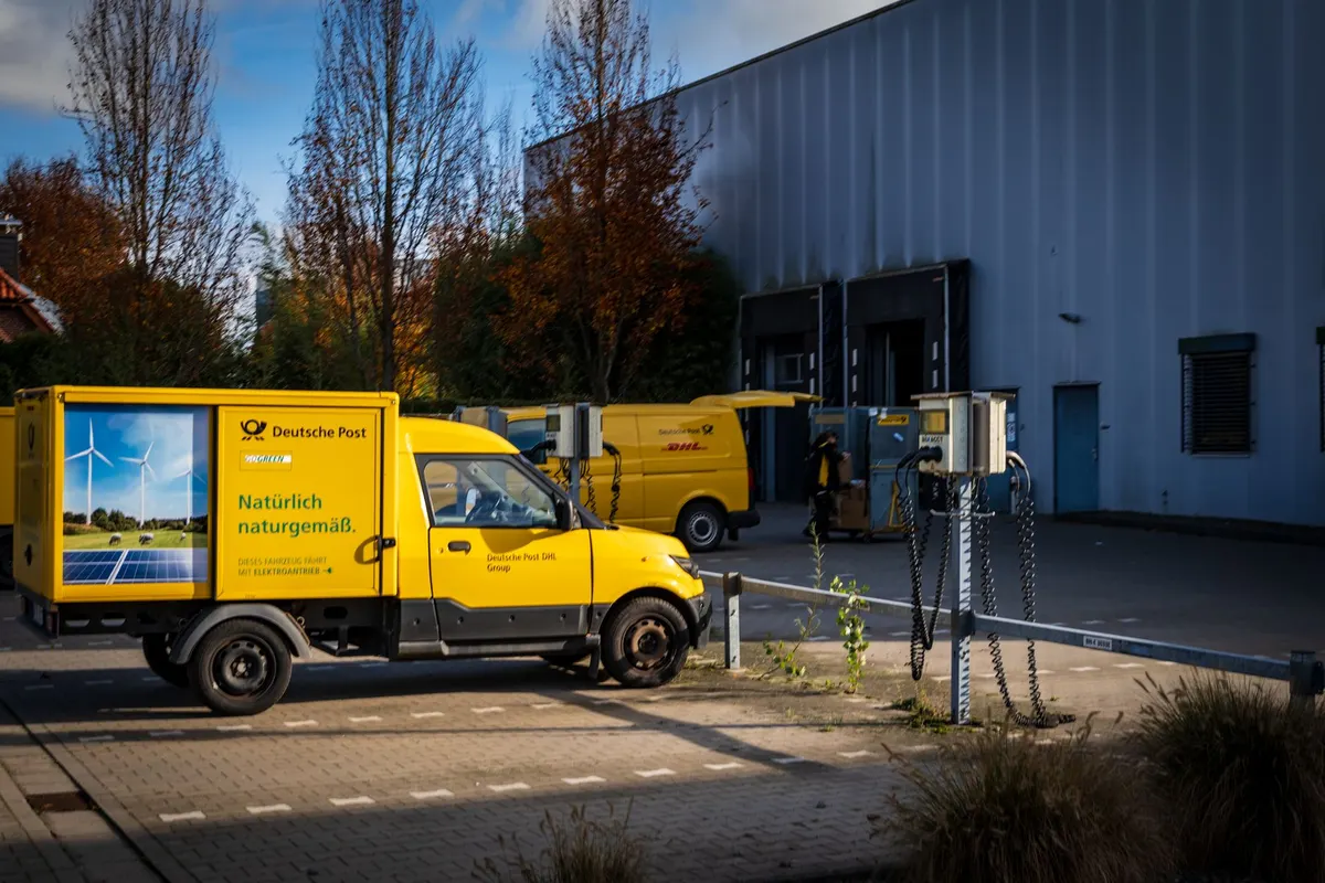 Flotte de véhicules utilitaires électriques en recharge sur un site d'entreprise